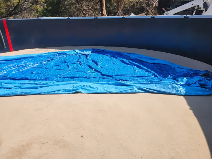 Liner being set inside an above-ground pool