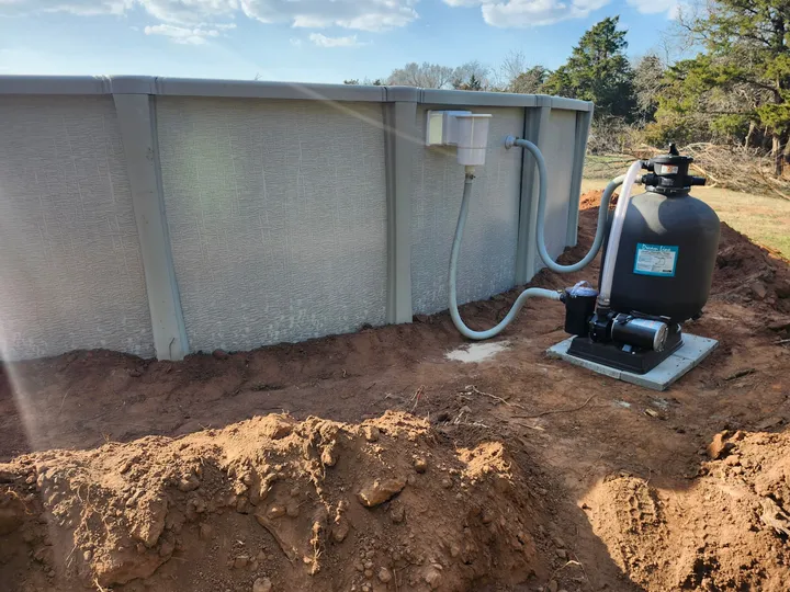 Above-ground pool with sand filter and pump plumbed