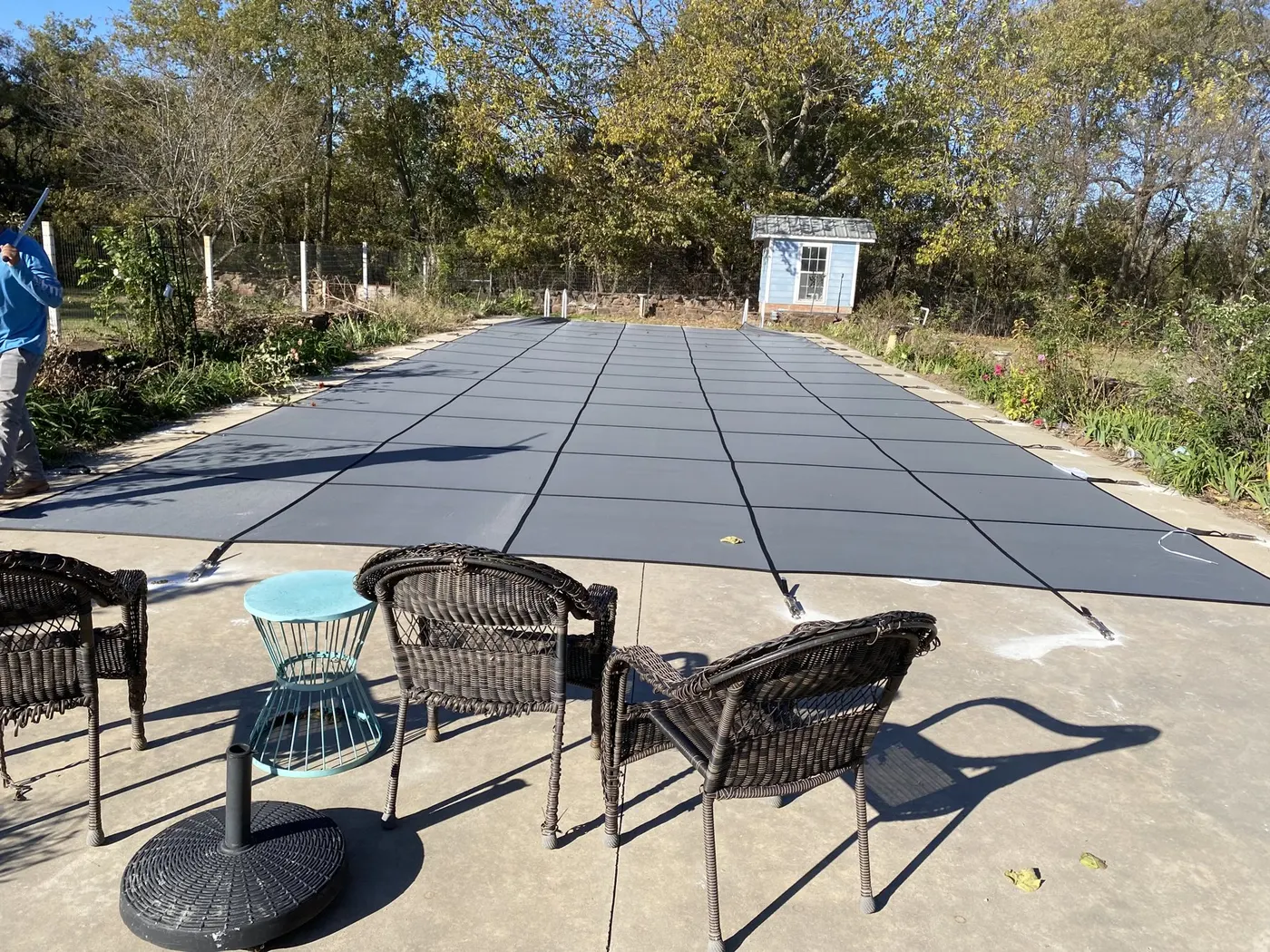 Same pool after renovation with a new deck, patio seating, and a fitted safety cover
