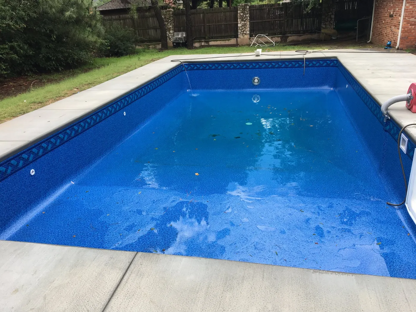 Same pool after renovation with a new blue vinyl liner and freshly poured concrete deck