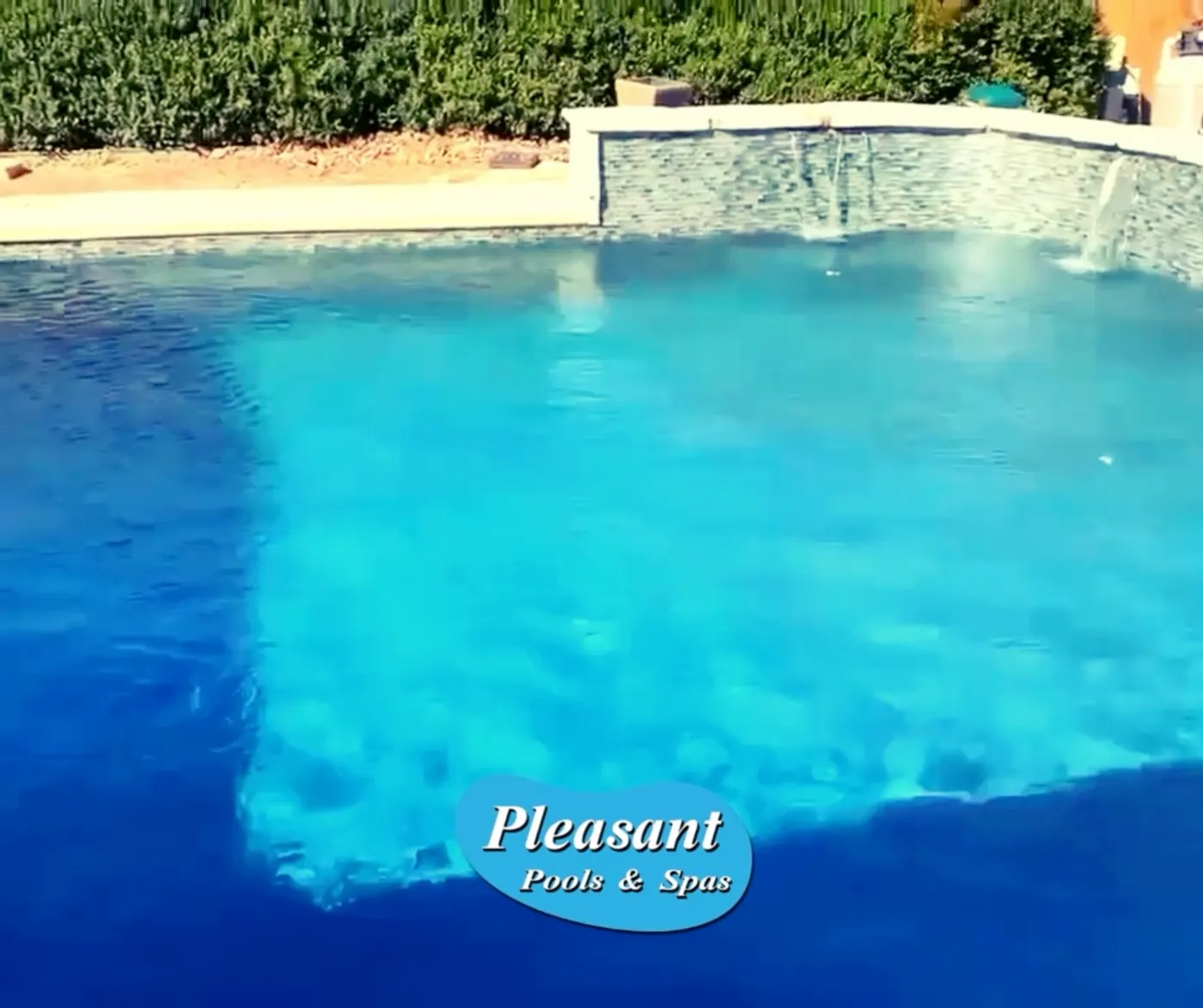 Renovated pool refilled, with new finish and waterfall wall running