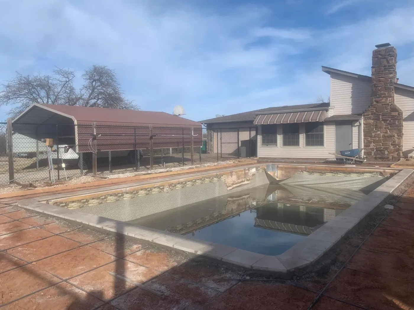 Aging pool with faded liner and worn deck before renovation