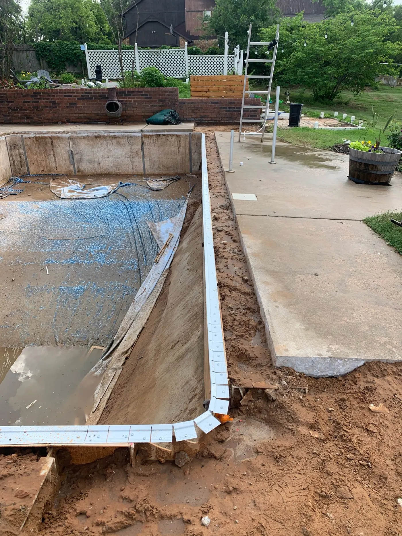 L-shaped pool with old liner removed and wall excavated before renovation