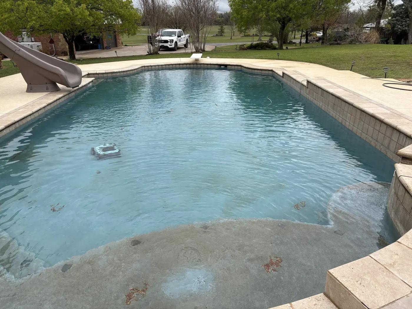 Dated pool with worn tan coping and cloudy water before renovation