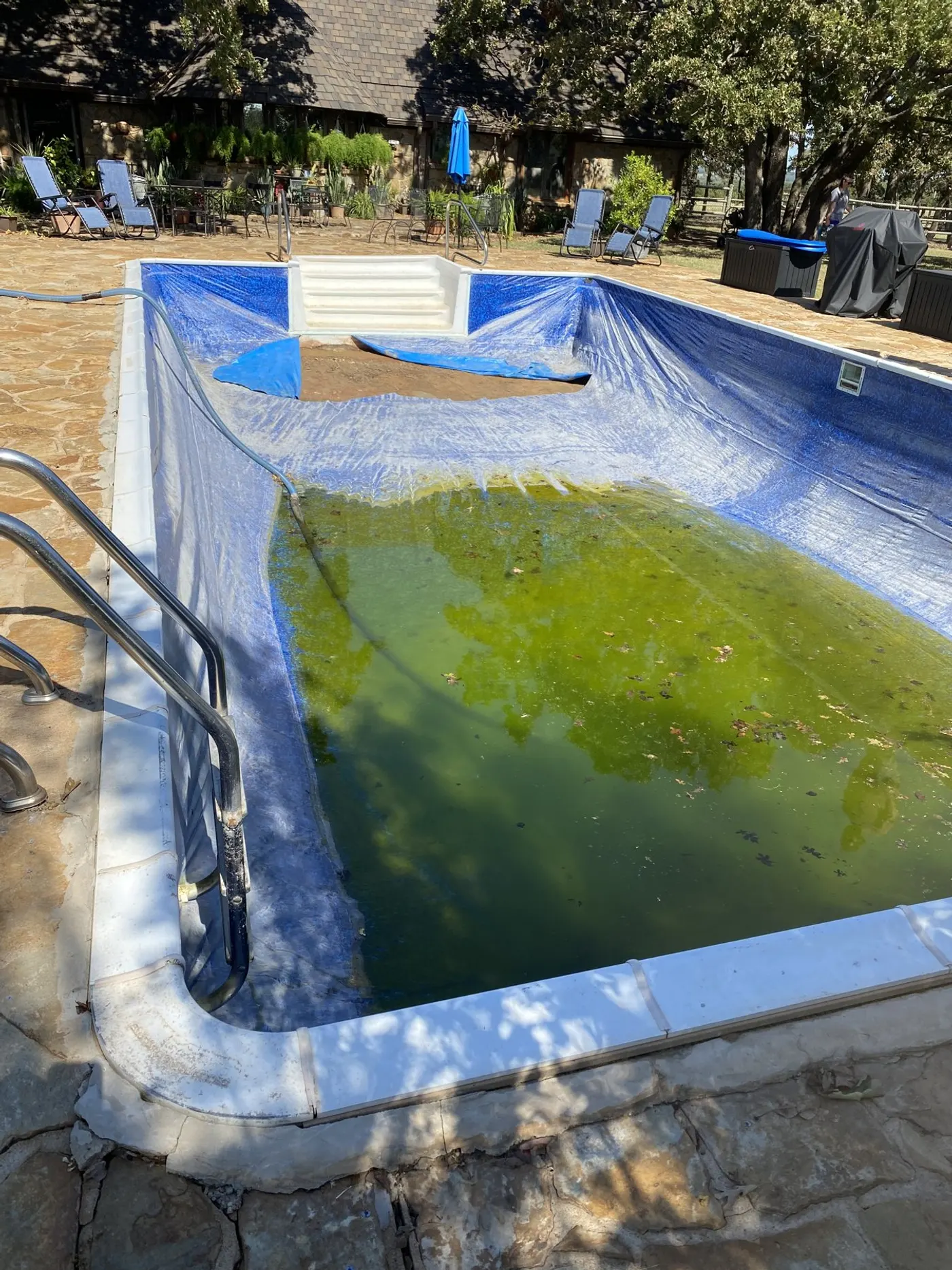 Vinyl pool with a sagging old liner and green water before renovation