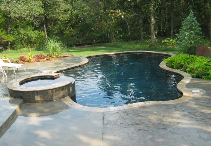 Curved pool with integrated spa and extensive rock/water feature landscaping