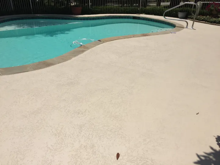 Textured tan deck coating around a freeform pool