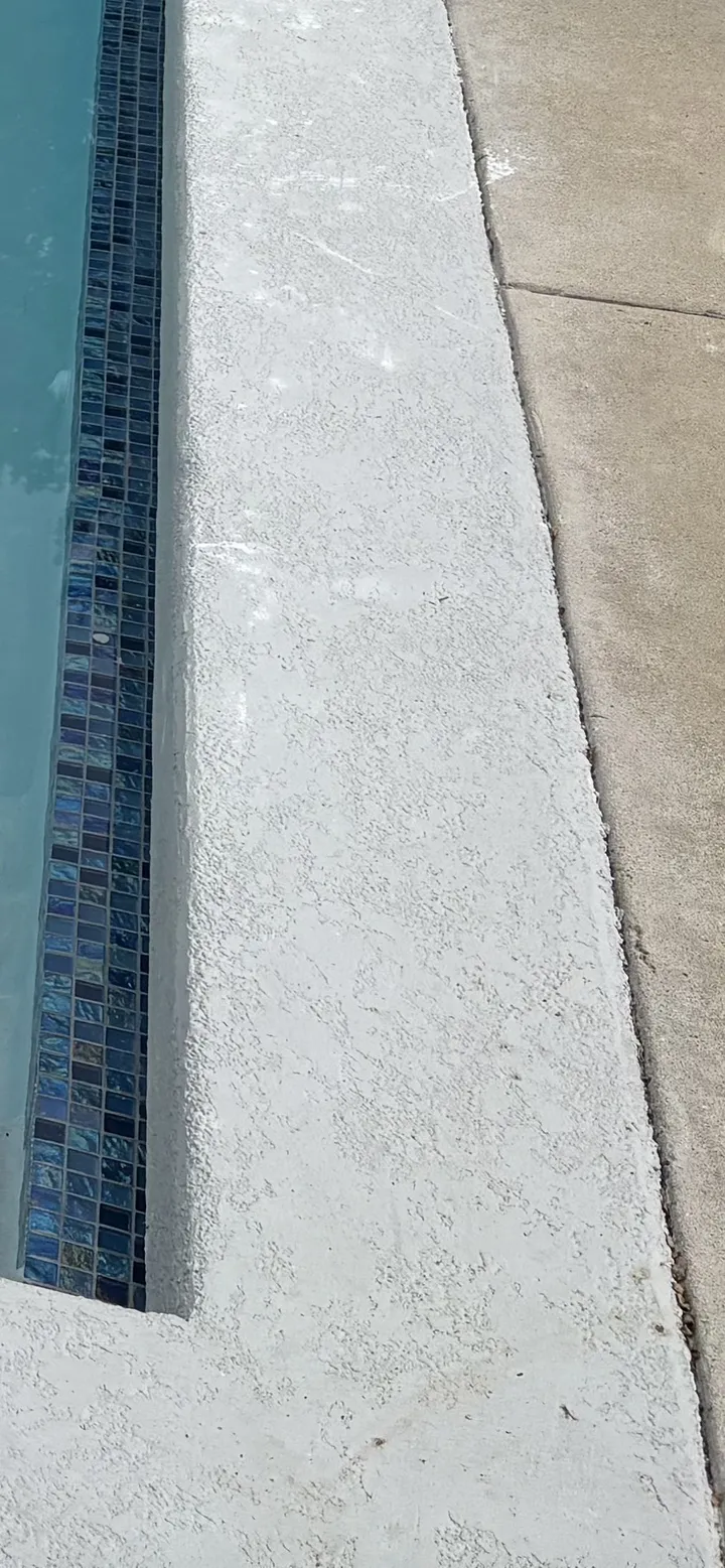 Deck coating edge detail against glass waterline tile