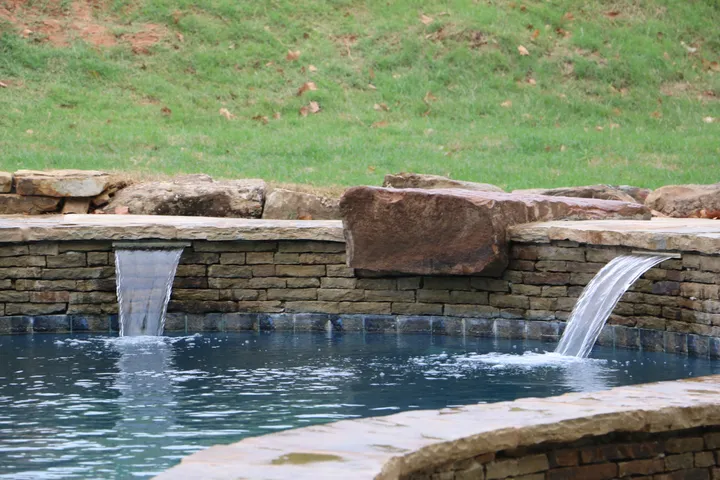 Stone pool with dual waterfall jets creating sheet water effects