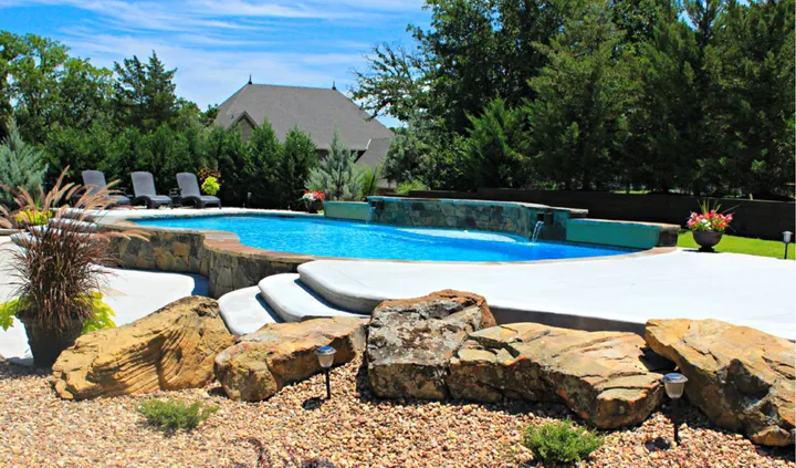 Elegant freeform pool with integrated steps and stone waterfall