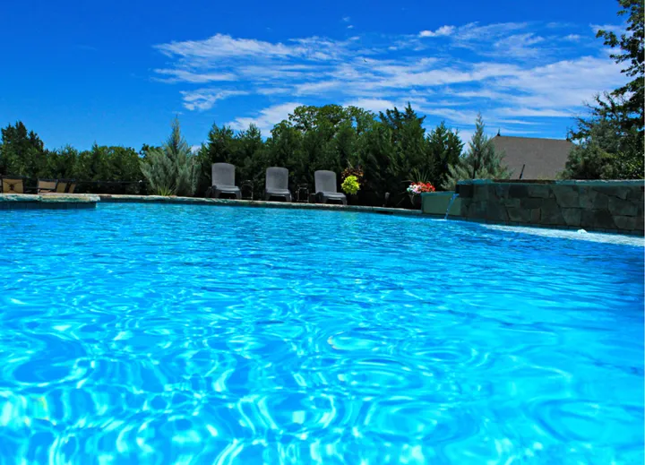Pool with freeform shape, spa, waterfall feature and landscaping