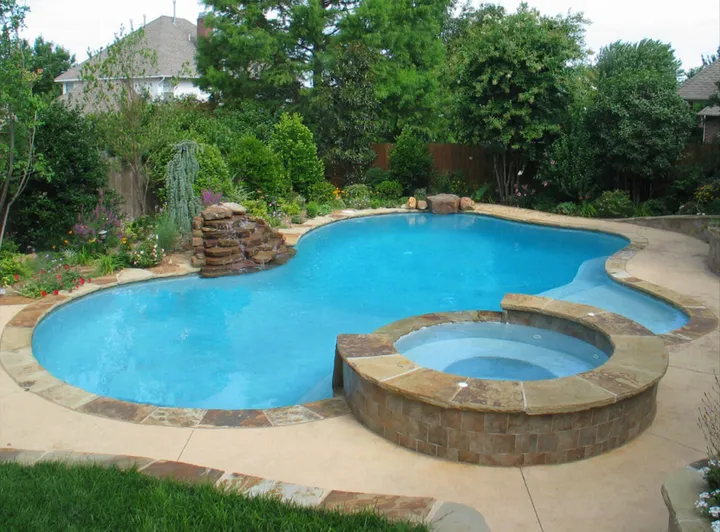 Curved pool with integrated spa feature in residential setting