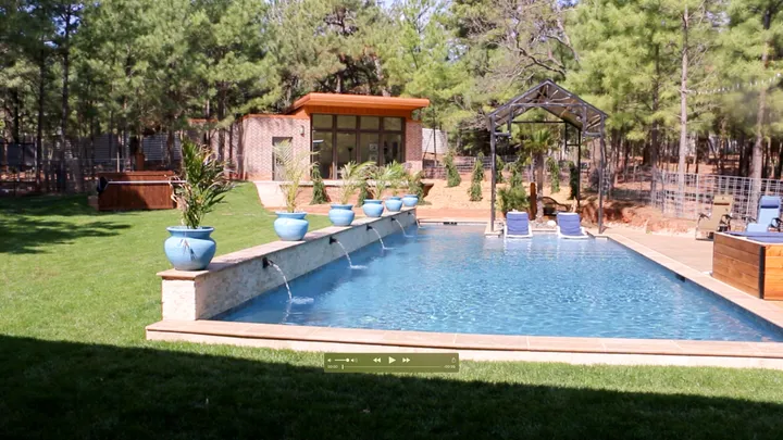 Rectangular pool with integrated spa and modern stonework in mature landscape