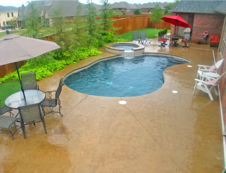Large backyard pool with patio furniture and landscaping