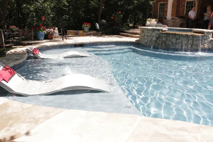 Luxurious backyard entertainment space with modern pool and stone features