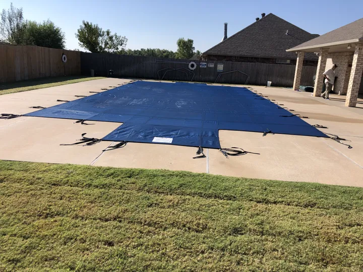 Blue safety cover fitted to a rectangular pool