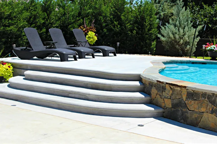Pool with curved water feature wall and lounge deck area